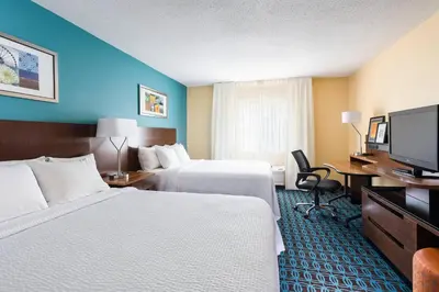 a hotel room with two beds and a flat screen tv at Fairfield Inn & Suites Findlay in Findlay