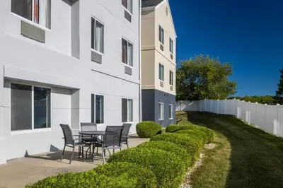 a patio with chairs and a table next to a building at Fairfield Inn by Marriott Richmond in New Paris