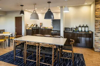a dining room with a table and chairs and a kitchen at Fairfield Inn by Marriott Richmond in New Paris