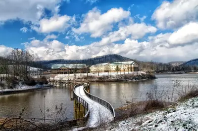 a bridge over a river with snow on the ground at Stonewall Resort in Roanoke