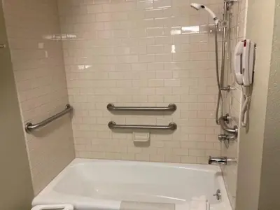 a bathroom with a bath tub and a phone at Stonewall Resort in Roanoke