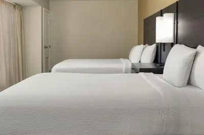 two beds in a hotel room with white sheets and pillows at Residence Inn Dayton North in Dayton