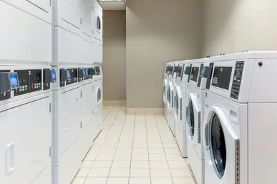 a laundry room with a row of washers and dryers at Residence Inn Dayton North in Dayton