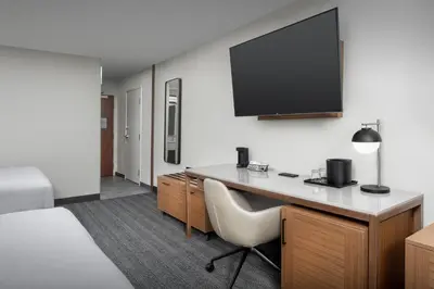 a hotel room with a desk and a flat screen tv at Courtyard by Marriott Dayton Beavercreek in Beavercreek