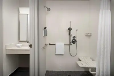 a white bathroom with a shower and a sink at Courtyard by Marriott Dayton Beavercreek in Beavercreek