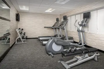 a gym with treadmills and machines in a room at Courtyard by Marriott Dayton Beavercreek in Beavercreek