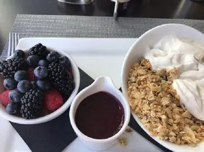 a tray with a bowl of fruit and a bowl of yogurt at Courtyard by Marriott Dayton Beavercreek in Beavercreek