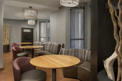 a waiting room with tables and chairs and windows at Courtyard by Marriott Dayton Beavercreek in Beavercreek
