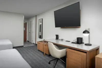 a hotel room with a desk and a flat screen tv at Courtyard by Marriott Dayton Beavercreek in Beavercreek