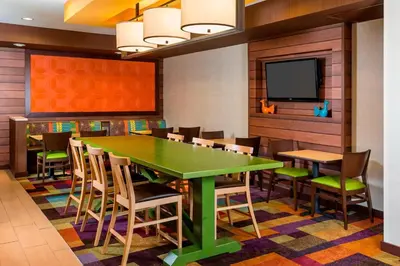 a dining room with a green table and chairs at Fairfield Inn Muncie in Muncie