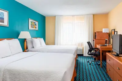 a hotel room with two beds and a television at Fairfield Inn Muncie in Muncie