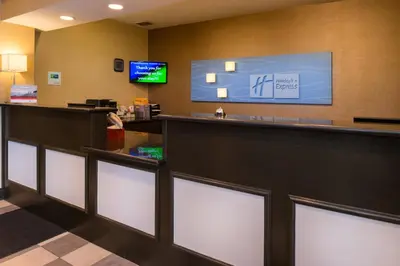 a hotel lobby with a reception counter and a tv at Holiday Inn Express & Suites Bucyrus by IHG in Bucyrus