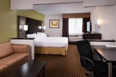 a hotel room with a bed and a couch at Holiday Inn Express & Suites Bucyrus by IHG in Bucyrus