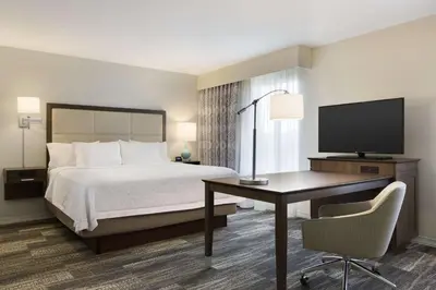 a hotel room with a bed and a desk and a television at Hampton Inn & Suites Niles/Warren, OH in Niles