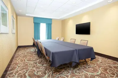 a conference room with a table and chairs and a television at Hampton Inn & Suites Niles/Warren, OH in Niles