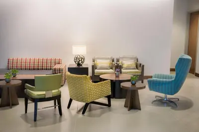 a waiting room with chairs and tables and a table andchairs at The Hotel at Oberlin in Oberlin
