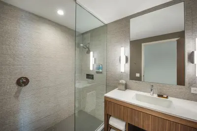a bathroom with a sink and a glass shower at The Hotel at Oberlin in Oberlin