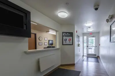 a hallway with a flat screen tv on a wall at HomeTowne Studios by Red Roof Columbus in Columbus