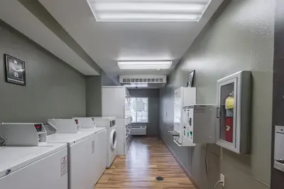 a laundry room with white washers and dryers at HomeTowne Studios by Red Roof Columbus in Columbus