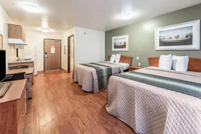 a hotel room with two beds and a flat screen tv at HomeTowne Studios by Red Roof Columbus in Columbus