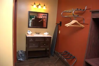 a bathroom with a sink and a mirror and hangers at Commodore Resort in Put-in-Bay