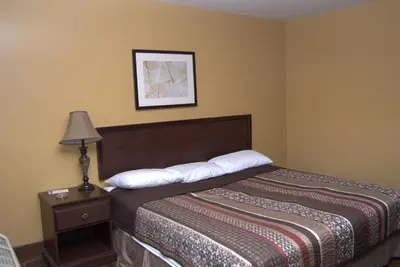 a hotel room with a bed and a lamp at Commodore Resort in Put-in-Bay