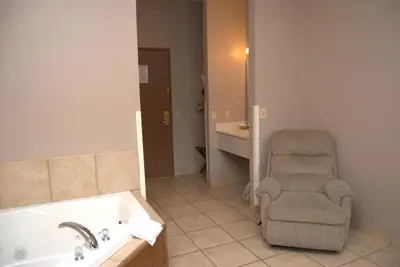 a bathroom with a chair and a bath tub at Commodore Resort in Put-in-Bay