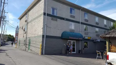 two people standing in the doorway of a building at Commodore Resort in Put-in-Bay