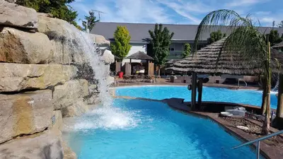 a water slide in a pool with a waterfall at Commodore Resort in Put-in-Bay