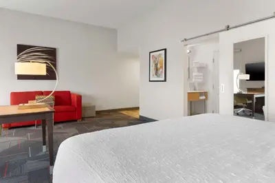 a white room with a bed and a red couch at Hampton Inn & Suites Columbus Scioto Downs in Columbus
