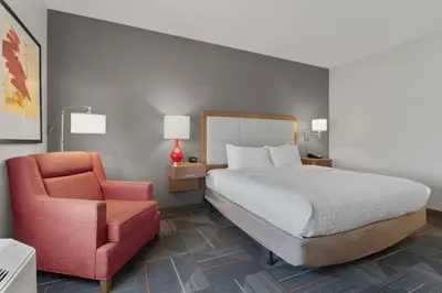 a bedroom with a bed and a chair at Hampton Inn & Suites Columbus Scioto Downs in Columbus