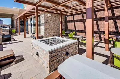 an outdoor patio with a stone grill and tables at SpringHill Suites by Marriott Dayton Vandalia in Murlin Heights