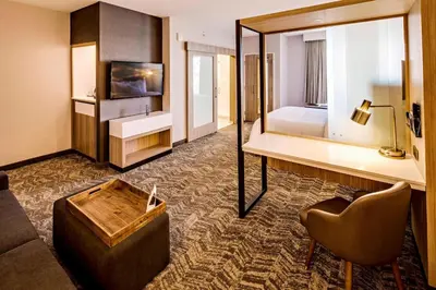 a hotel room with a bed and a couch and a mirror at SpringHill Suites by Marriott Dayton Vandalia in Murlin Heights