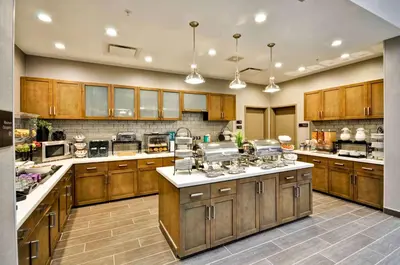 a large kitchen with wooden cabinets and white counter tops at Homewood Suites by Hilton Cincinnati/West Chester in West Chester