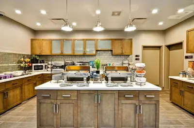 a large kitchen with wooden cabinets and white counter tops at Homewood Suites by Hilton Cincinnati/West Chester in West Chester