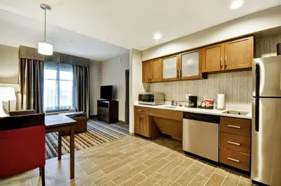 a large kitchen with wooden cabinets and a refrigerator at Homewood Suites by Hilton Cincinnati/West Chester in West Chester