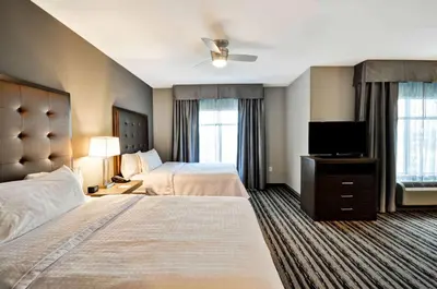 a hotel room with two beds and a flat screen tv at Homewood Suites by Hilton Cincinnati/West Chester in West Chester