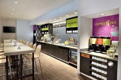 a coffee shop with a bar with chairs and a counter at Home2 Suites by Hilton Cleveland Independence in Independence