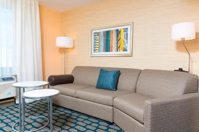 a living room with a couch in a hotel room at Fairfield Inn & Suites by Marriott Medina in Medina