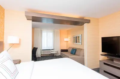 a hotel room with a bed and a couch and a television at Fairfield Inn & Suites by Marriott Medina in Medina