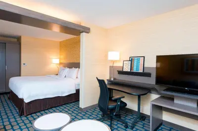 a hotel room with a bed and a desk with a television at Fairfield Inn & Suites by Marriott Medina in Medina
