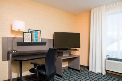 a hotel room with a desk with a monitor and a chair at Fairfield Inn & Suites by Marriott Medina in Medina