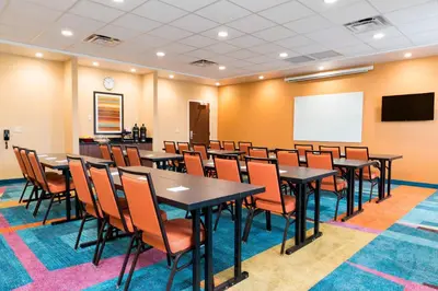 a conference room with tables and chairs and a whiteboard at Fairfield Inn & Suites by Marriott Medina in Medina