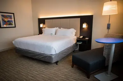 a hotel room with a bed and a table and a chair at Holiday Inn Express & Suites - Marietta by IHG in Marietta