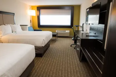 a hotel room with two beds and a flat screen tv at Holiday Inn Express & Suites - Marietta by IHG in Marietta
