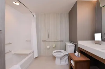 a bathroom with a toilet and a tub and a sink at Courtyard by Marriott Toledo North in Toledo