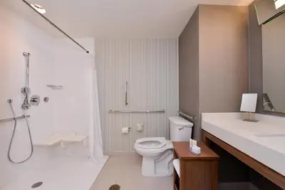 a bathroom with a toilet and a shower and a sink at Courtyard by Marriott Toledo North in Toledo