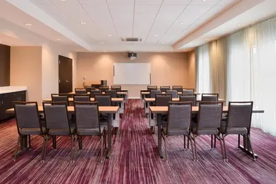 a conference room with tables and chairs and a whiteboard at Courtyard by Marriott Toledo North in Toledo