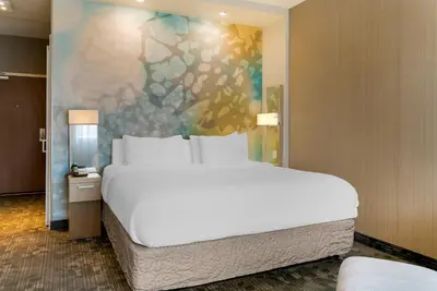 a bedroom with a large white bed and a painting at Courtyard by Marriott Toledo North in Toledo
