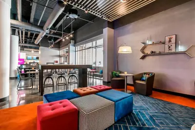 a living room with a couch and a bar at Aloft Newport on the Levee in Newport